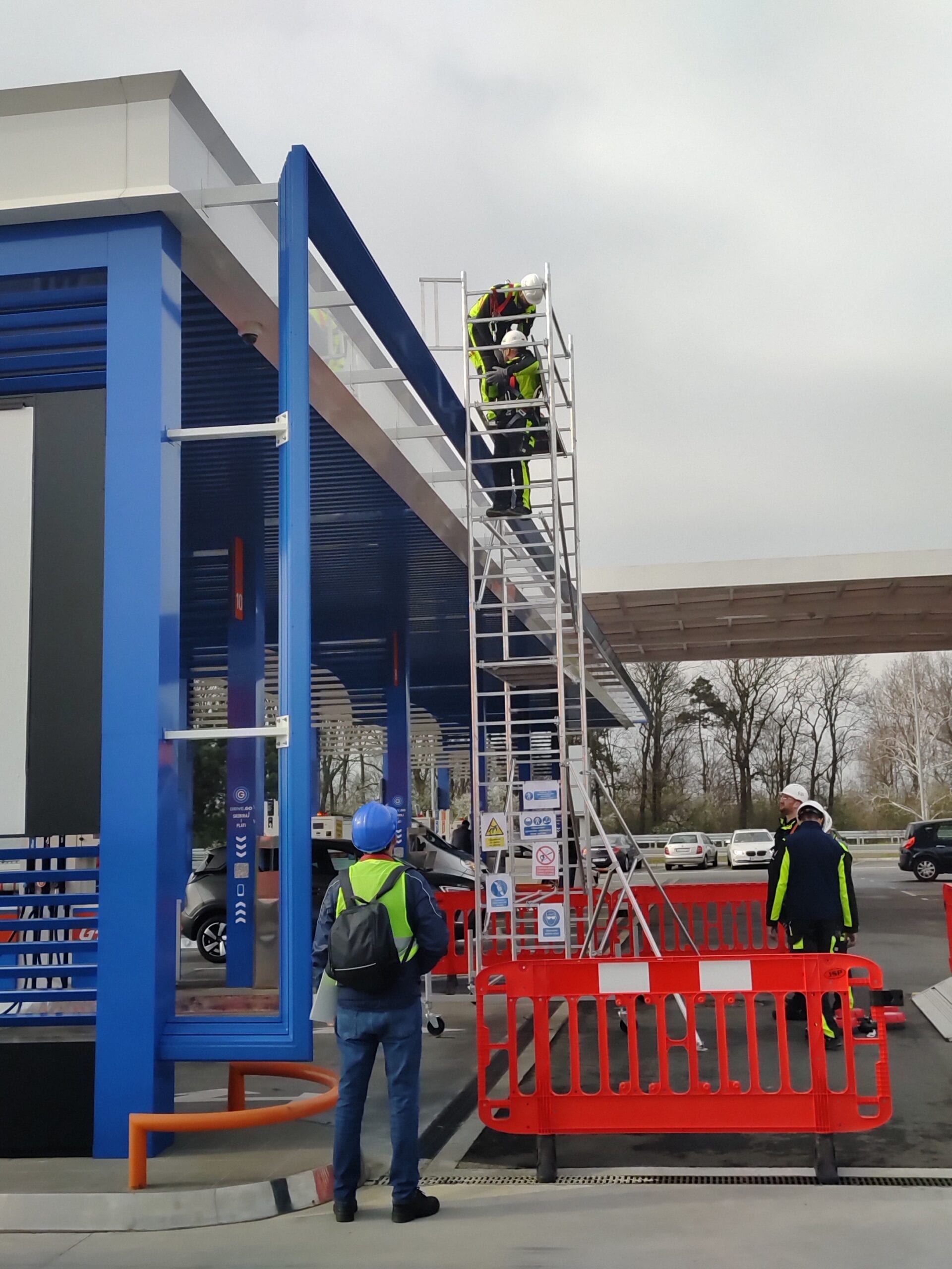 Radnici koriste aluminijumsku pokretnu skelu za pristup krovu nadstrešnice benzinske pumpe